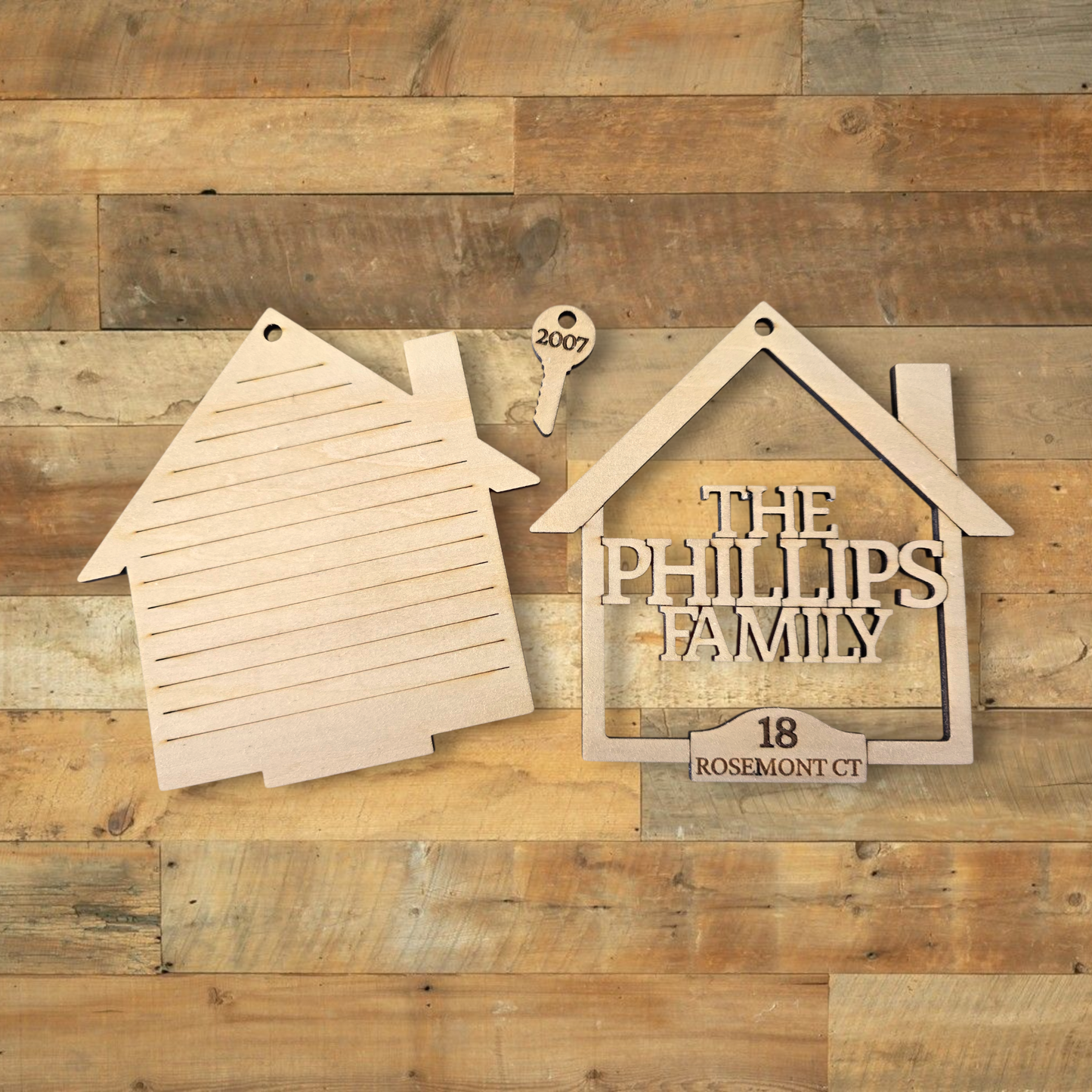 Wooden house-shaped sign with 'The Phillips Family' and address on a wooden background
