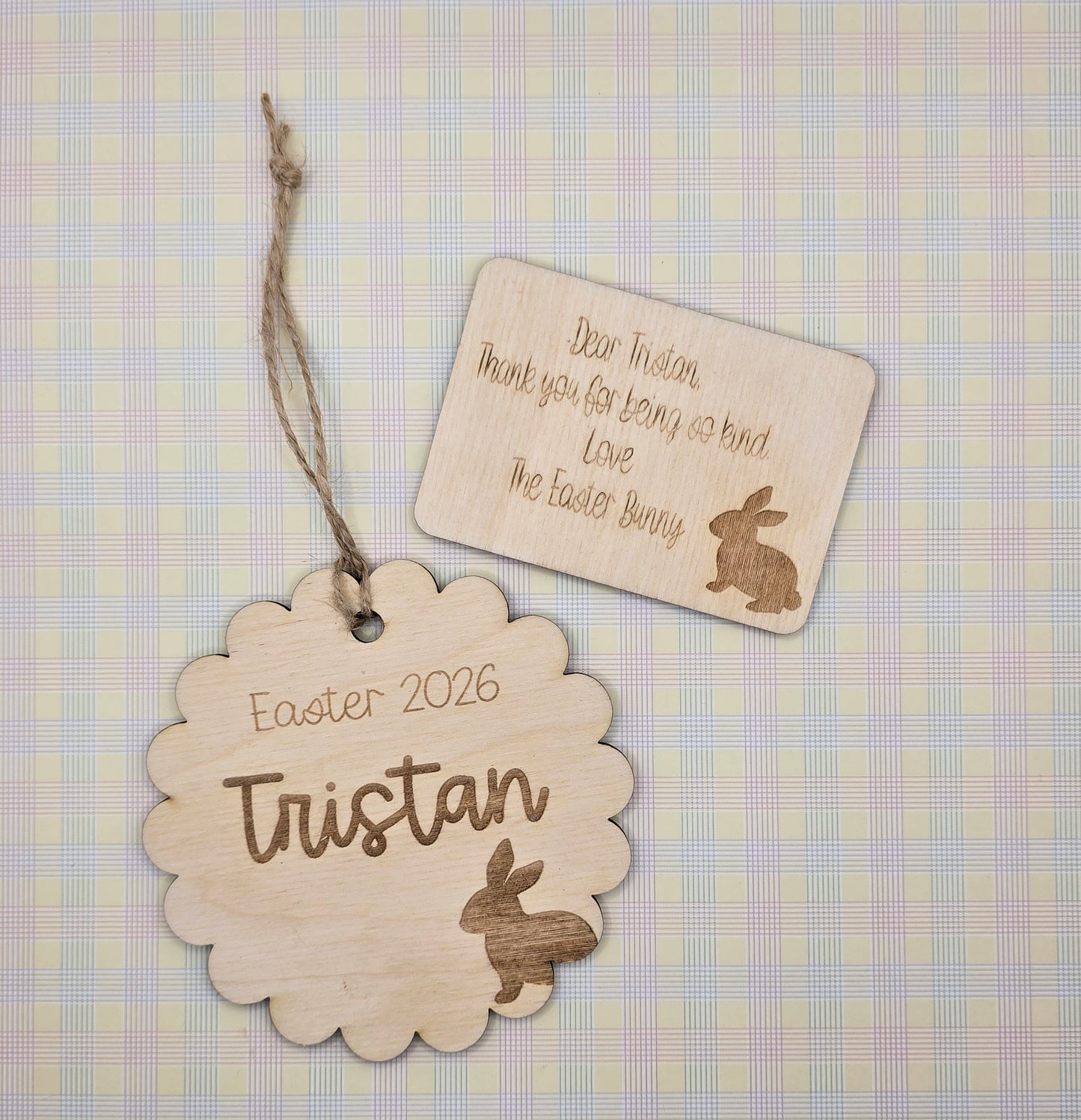 Wooden Easter tags with engraved names and bunny illustrations on a checkered background.
