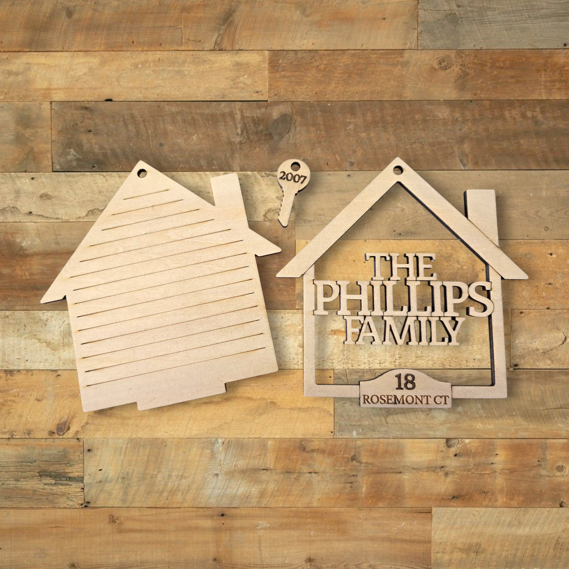 Wooden house-shaped sign with 'The Phillips Family' and address on a wooden background