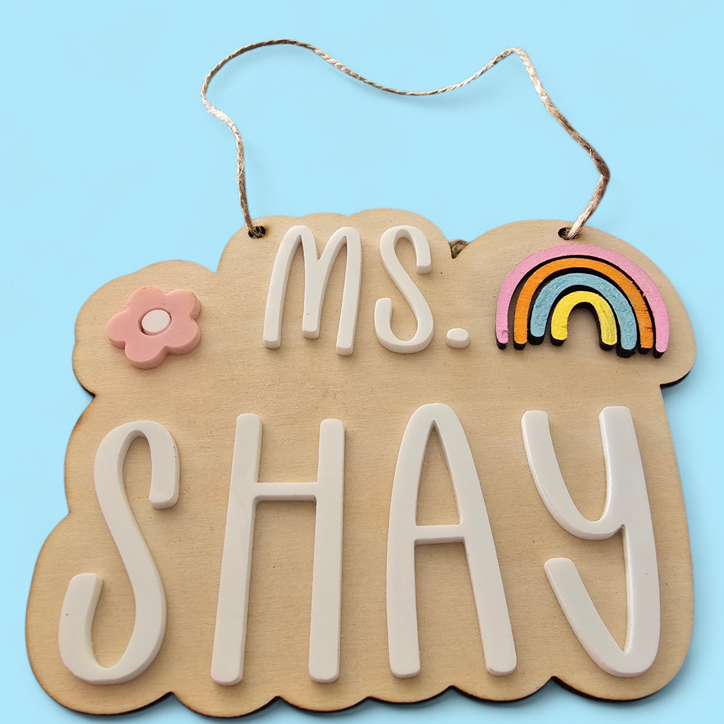 Decorative sign with 'MS. SHAY' text on a blue background