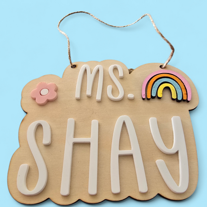 Decorative sign with 'MS. SHAY' text on a blue background