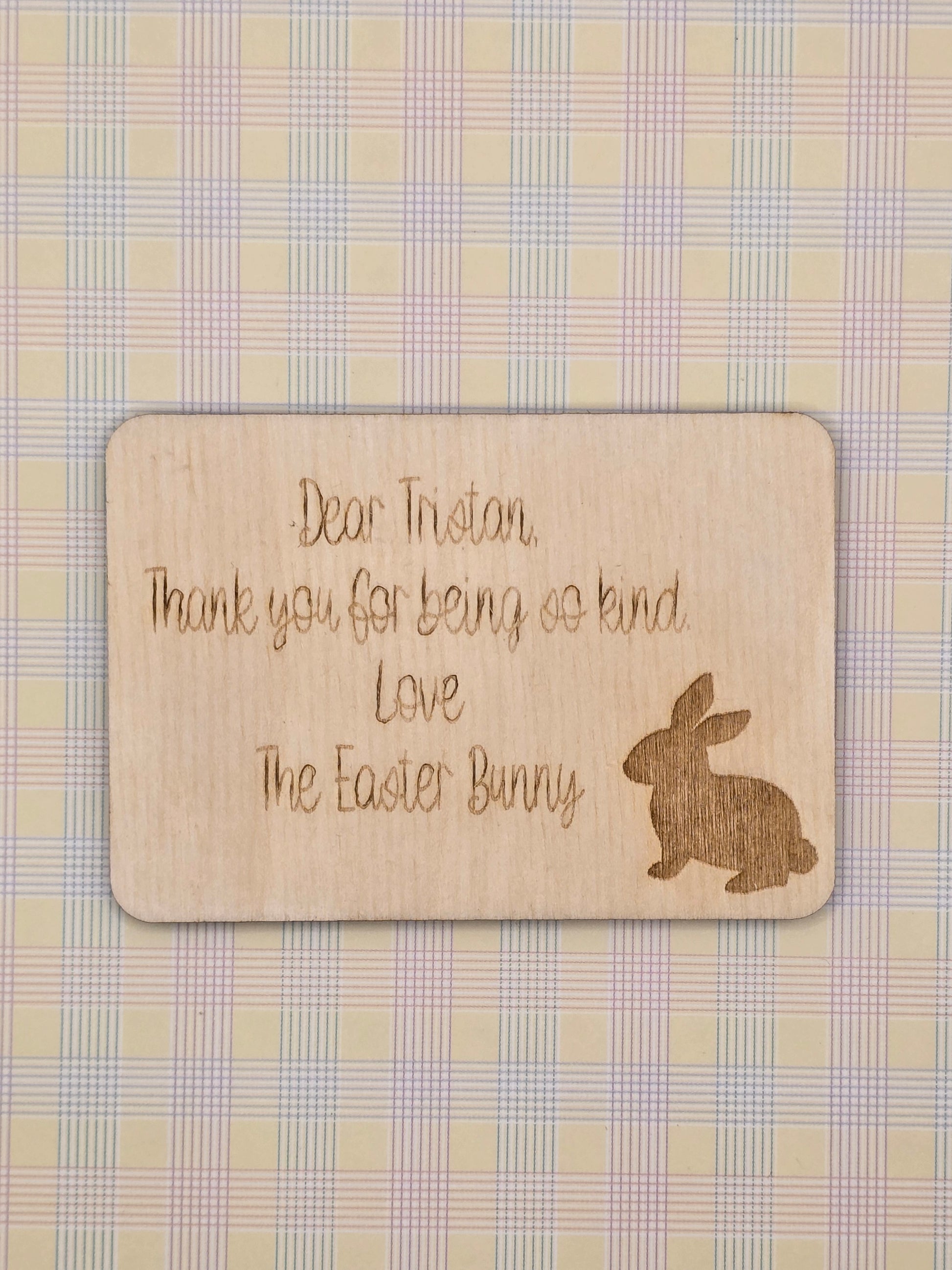 Wooden card with engraved text and Easter Bunny silhouette on a checkered background