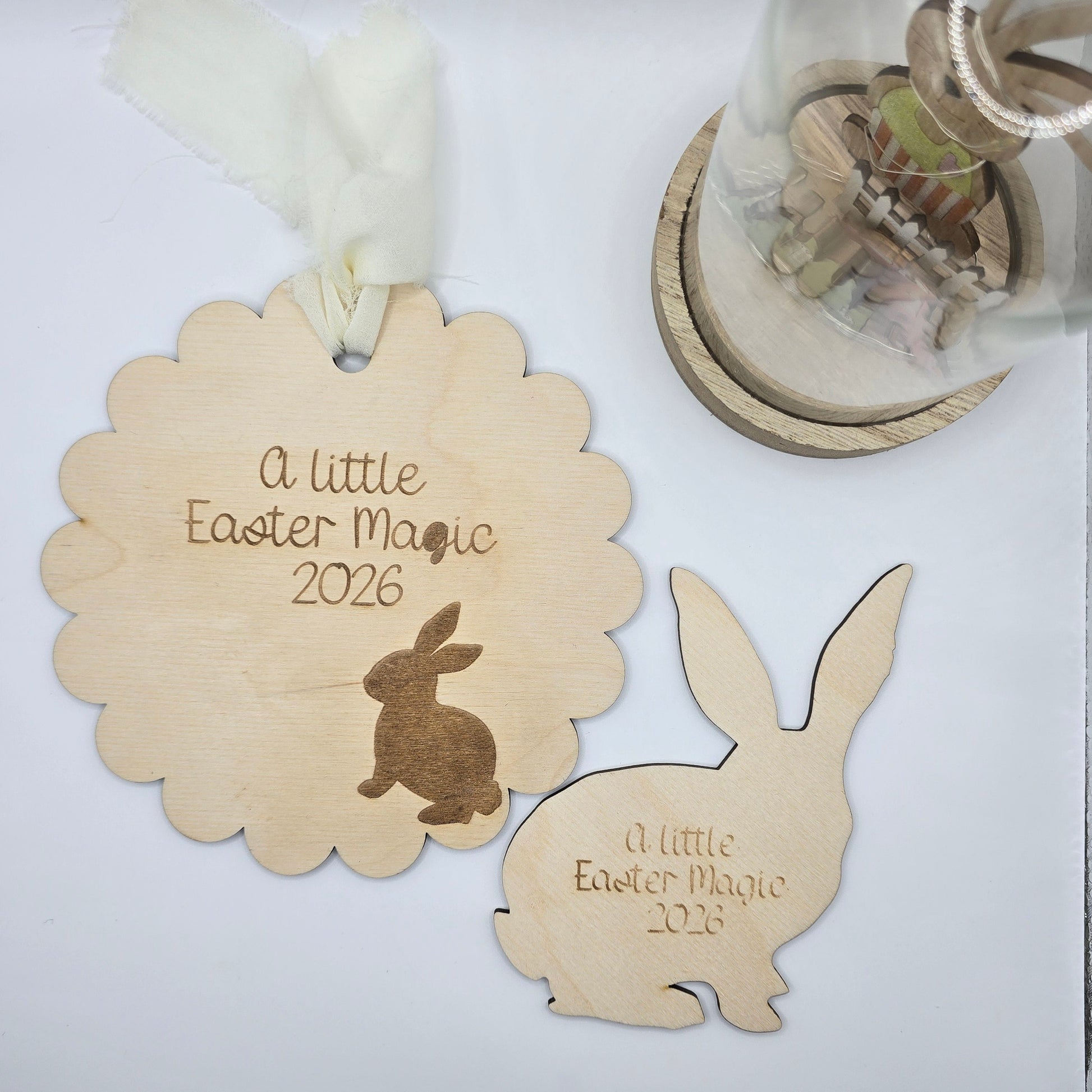 Wooden Easter decorations with text and a rabbit design on a white surface.