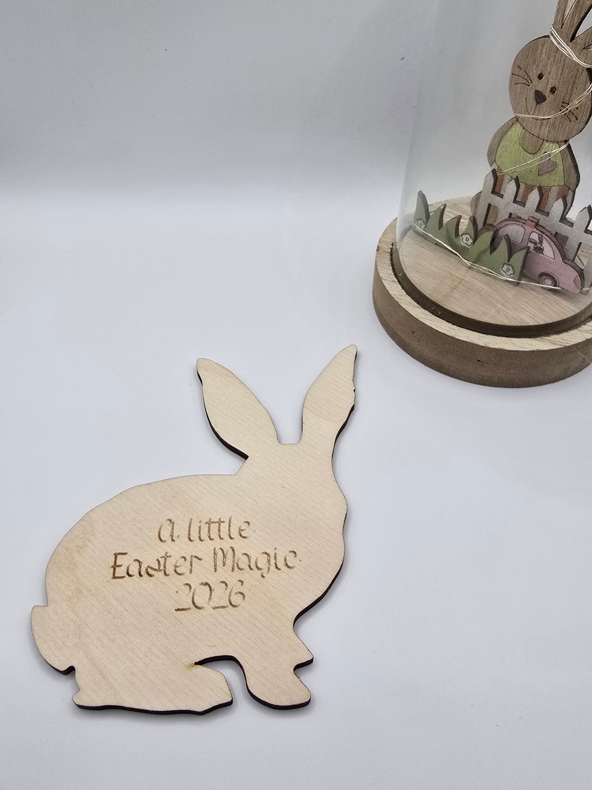 Wooden bunny cutout with 'A little Easter Magic 2023' text on a white background