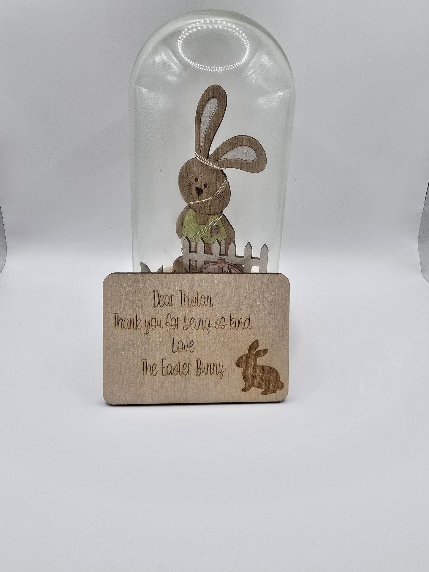 Glass bottle with wooden coaster featuring Easter-themed design on a white background