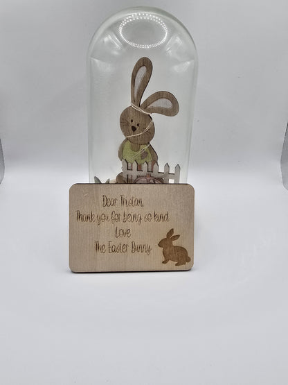 Glass bottle with wooden coaster featuring Easter-themed design on a white background