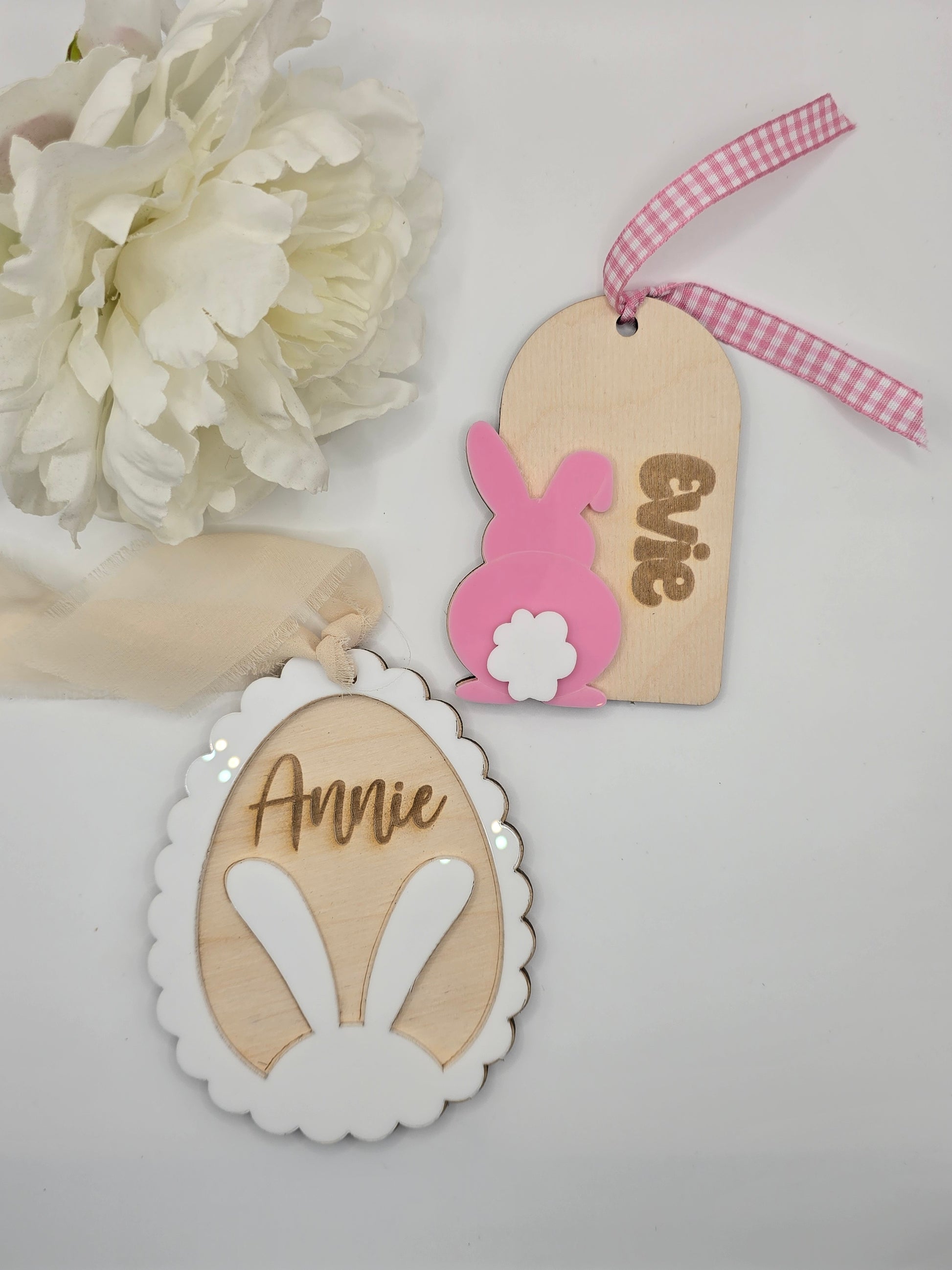 Decorative wooden tags with 'Evie' and 'Annie' on a white background with flowers.