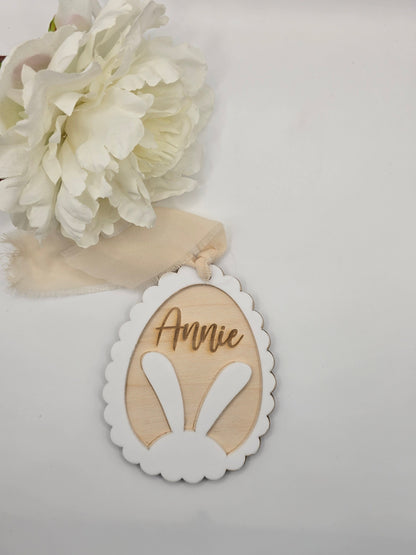 Decorative item with a name tag and white flowers on a light background