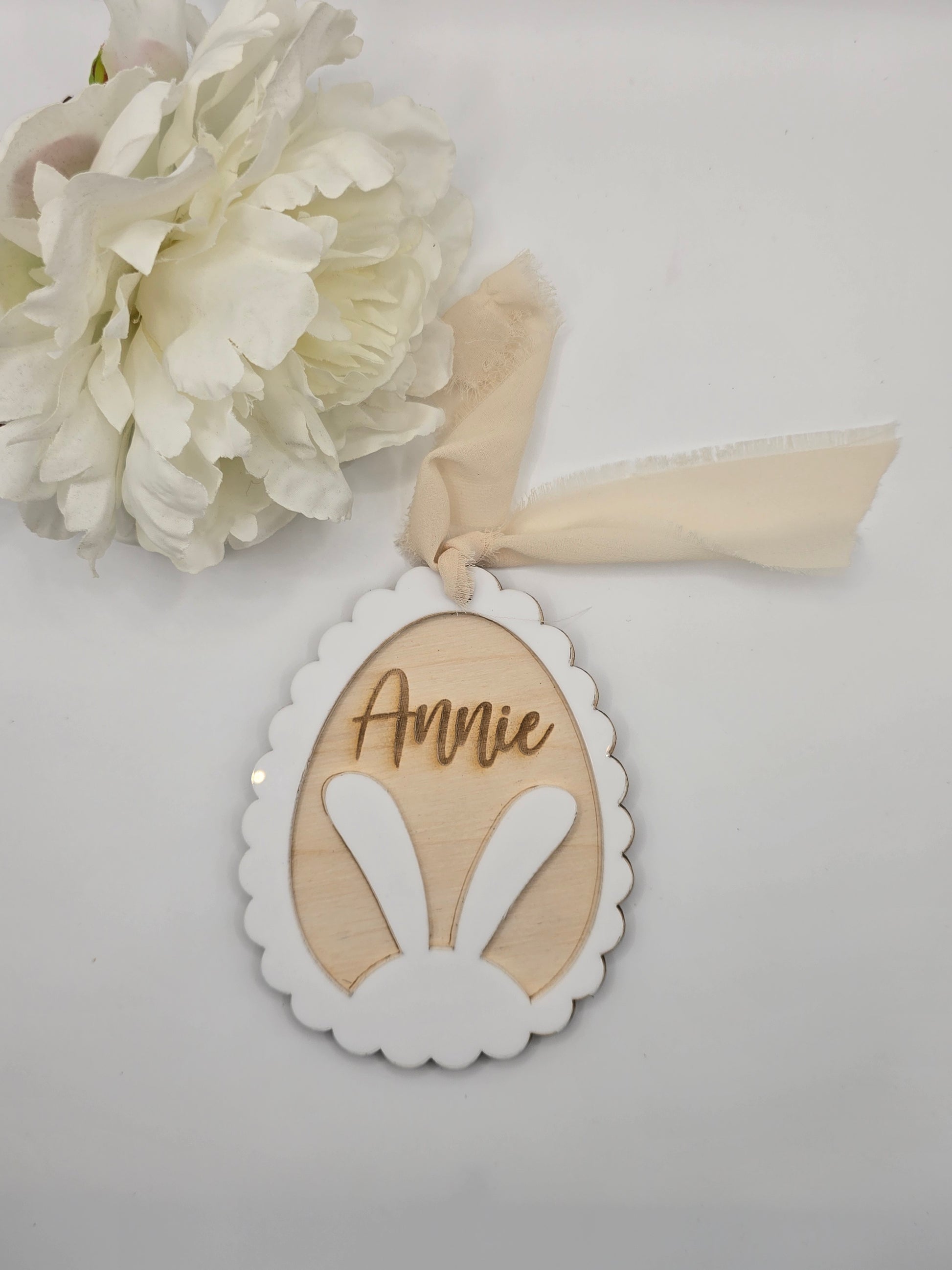 Decorative item with a ribbon and floral element on a light gray background