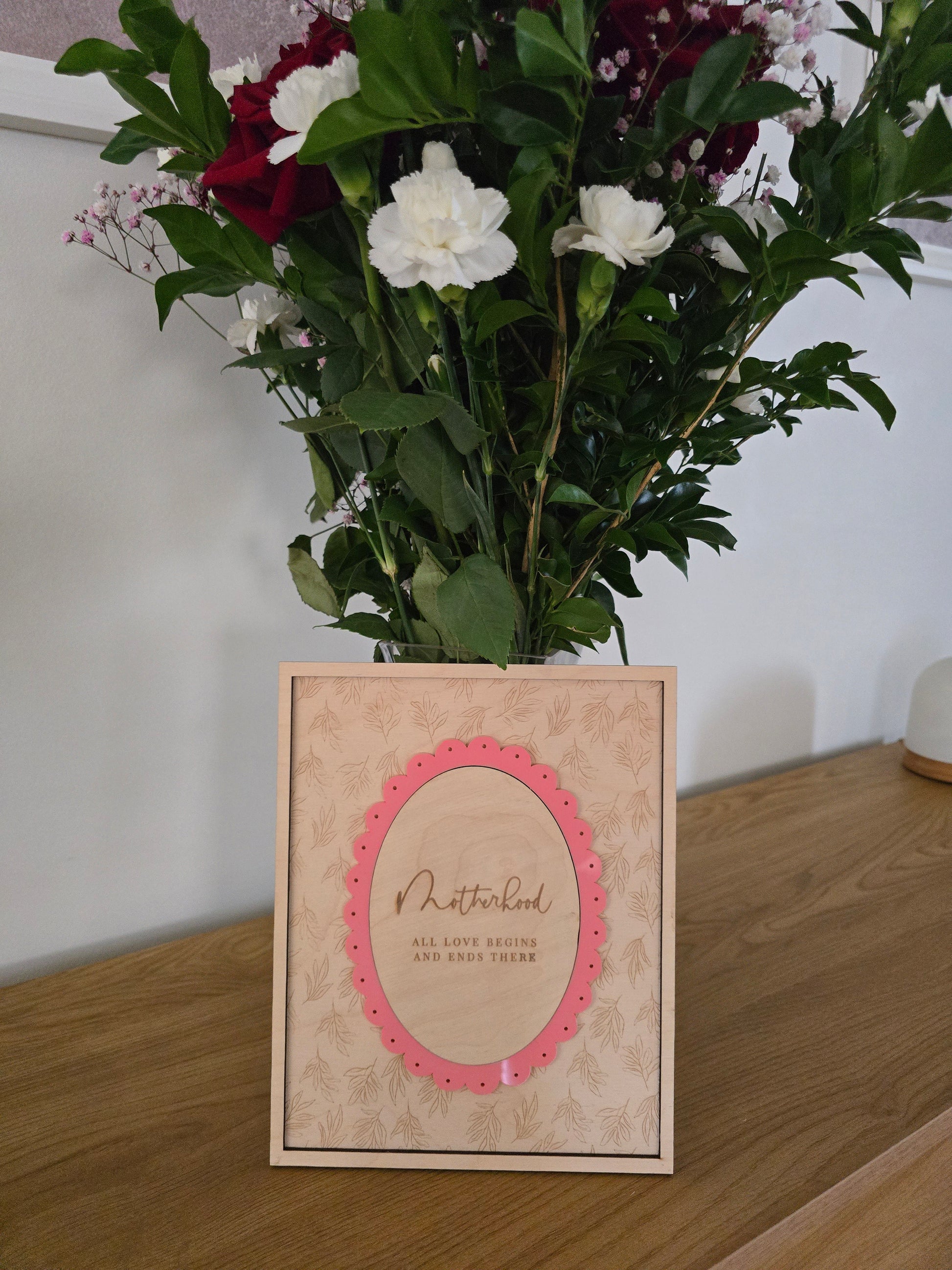Floral arrangement with a decorative card on a wooden surface