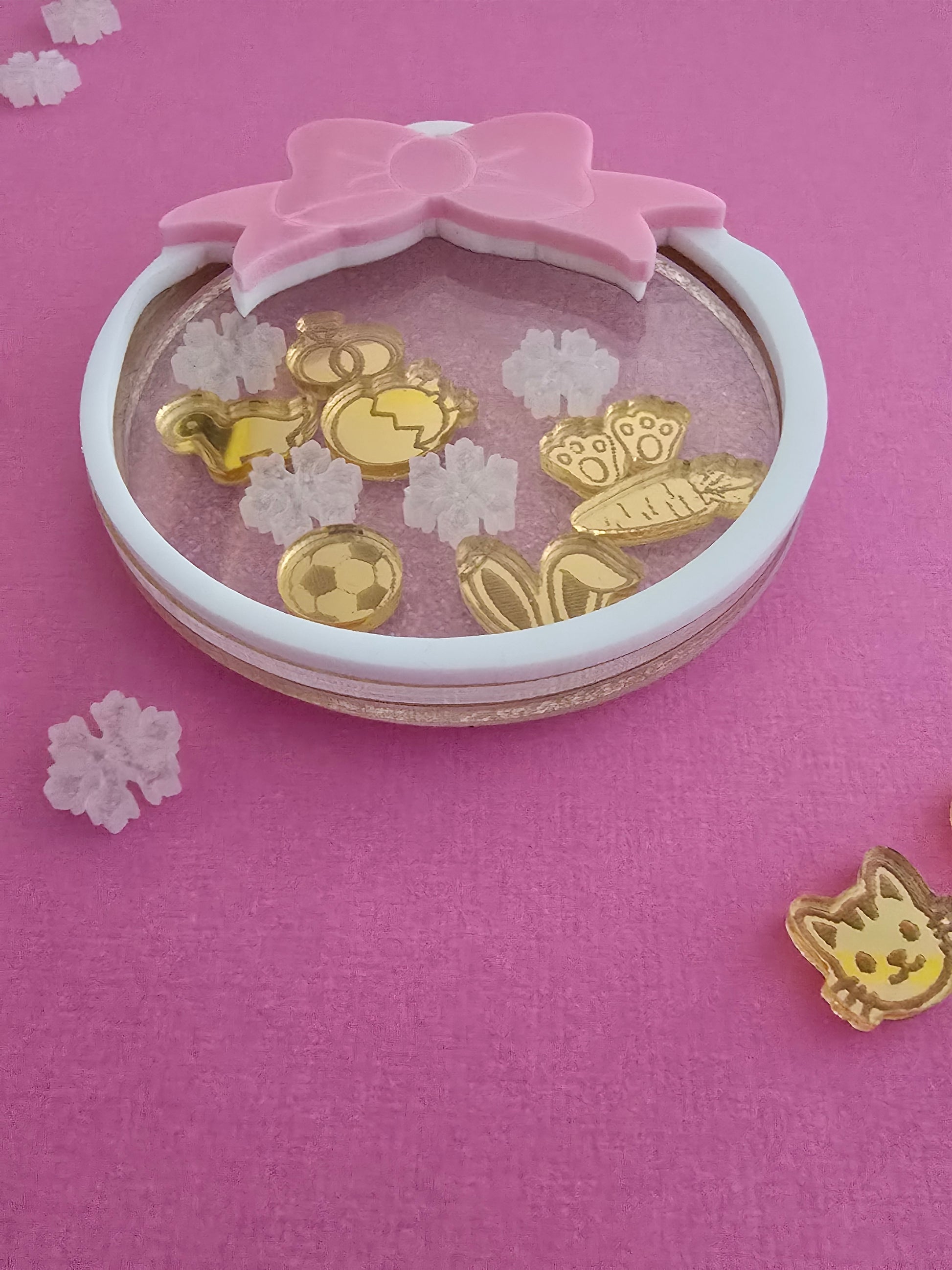 Compact mirror with gold butterfly designs on a pink background