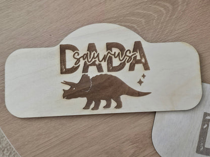 Wooden sign with 'DADASaurus' and a triceratops design on a wooden surface
