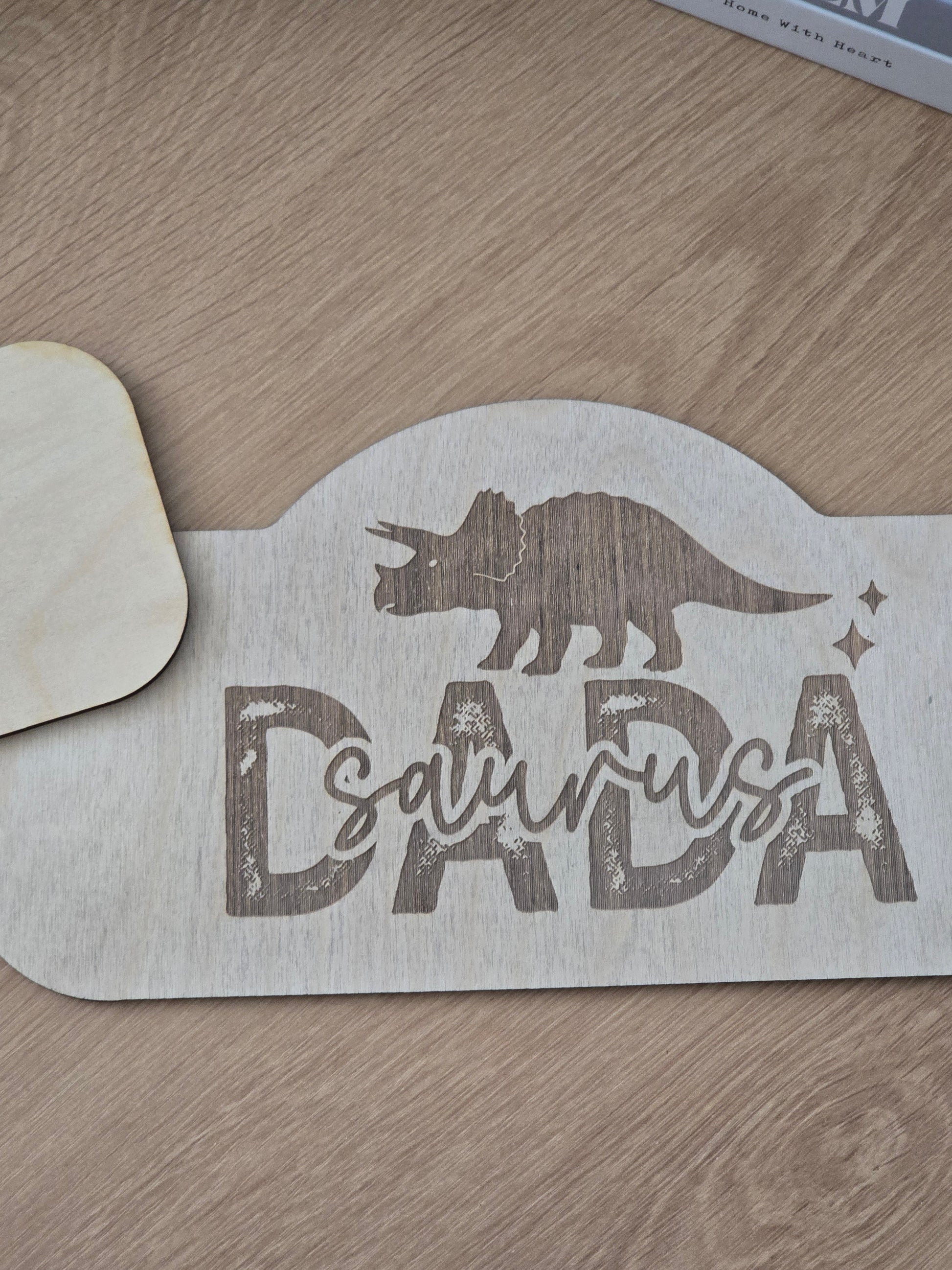 Wooden dinosaur-shaped sign with 'Dinosaur' text on a wooden surface