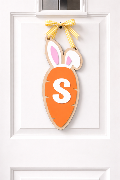 Easter carrot initial door hanger by PeppaTree Designs featuring a vibrant orange carrot with a personalized initial for spring decor.