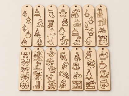 Twelve rectangular wooden tag ornaments with hanging holes, arranged in two rows on a light beige background. Each tag is engraved with different Christmas-themed illustrations including ornaments, trees, stockings, gingerbread men, hats, gifts, bows, leaves, candy canes, Santa, and mugs.