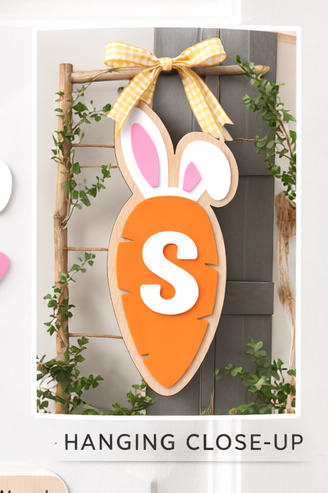 Decorative carrot-shaped sign with bunny ears and letter 'S' on a white door.