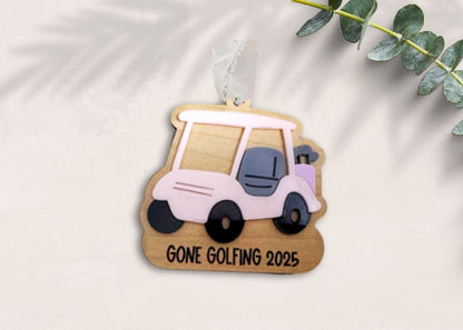 Decorative ornament with a golf cart design and 'Gone Golfing 2023' text on a light background.