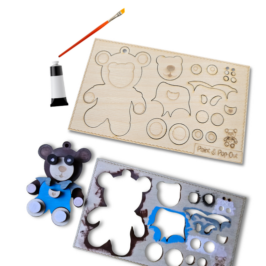 Wooden bear toy with paintbrushes and paint can on a white background
