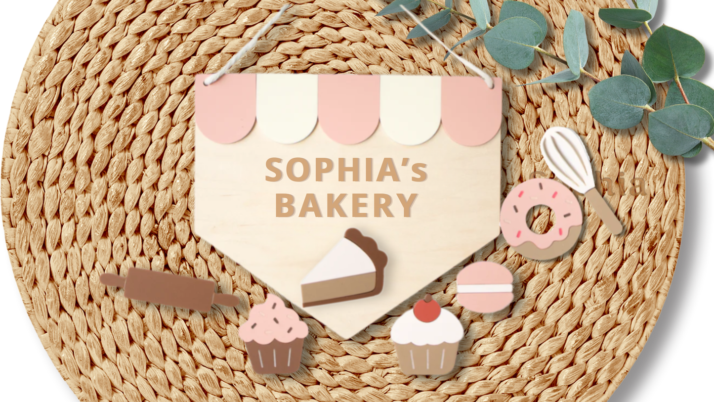 Custom wooden kids decor sign reading "Name’s Bakery" by PeppaTree Designs, featuring playful bakery-themed design on natural wood background.