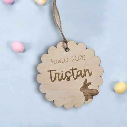 Wooden Easter tag with 'Easter 2026 Tristan' on a light blue background with pastel colored Easter eggs.