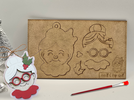 Cardboard cutout of a character with facial features and a paintbrush on a light background