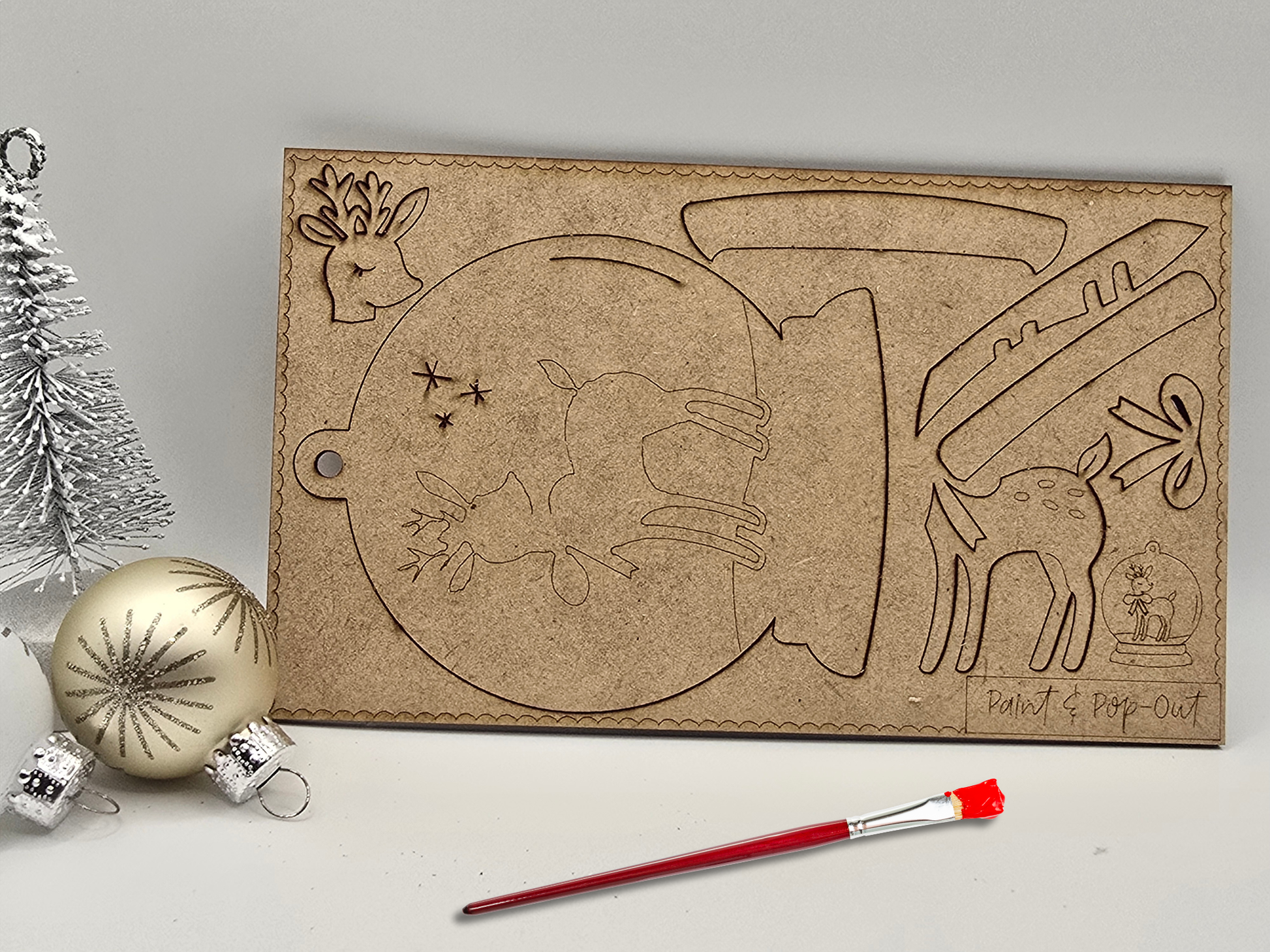 Decorative cardboard cutout with Christmas-themed designs on a gray background