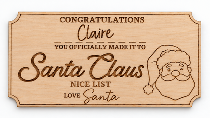 A personalized wooden plaque with engraved text reading 'Congratulations Claire you officially made it to Santa Claus Nice List Love Santa' and a line drawing of Santa's face and hat, shown on a white background.