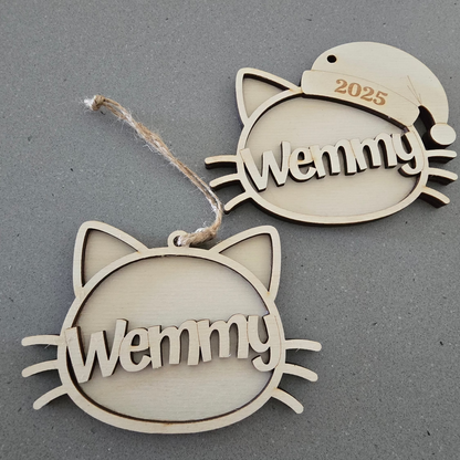 Two cat-shaped ornaments with 'Wemmy' engraved on a gray background