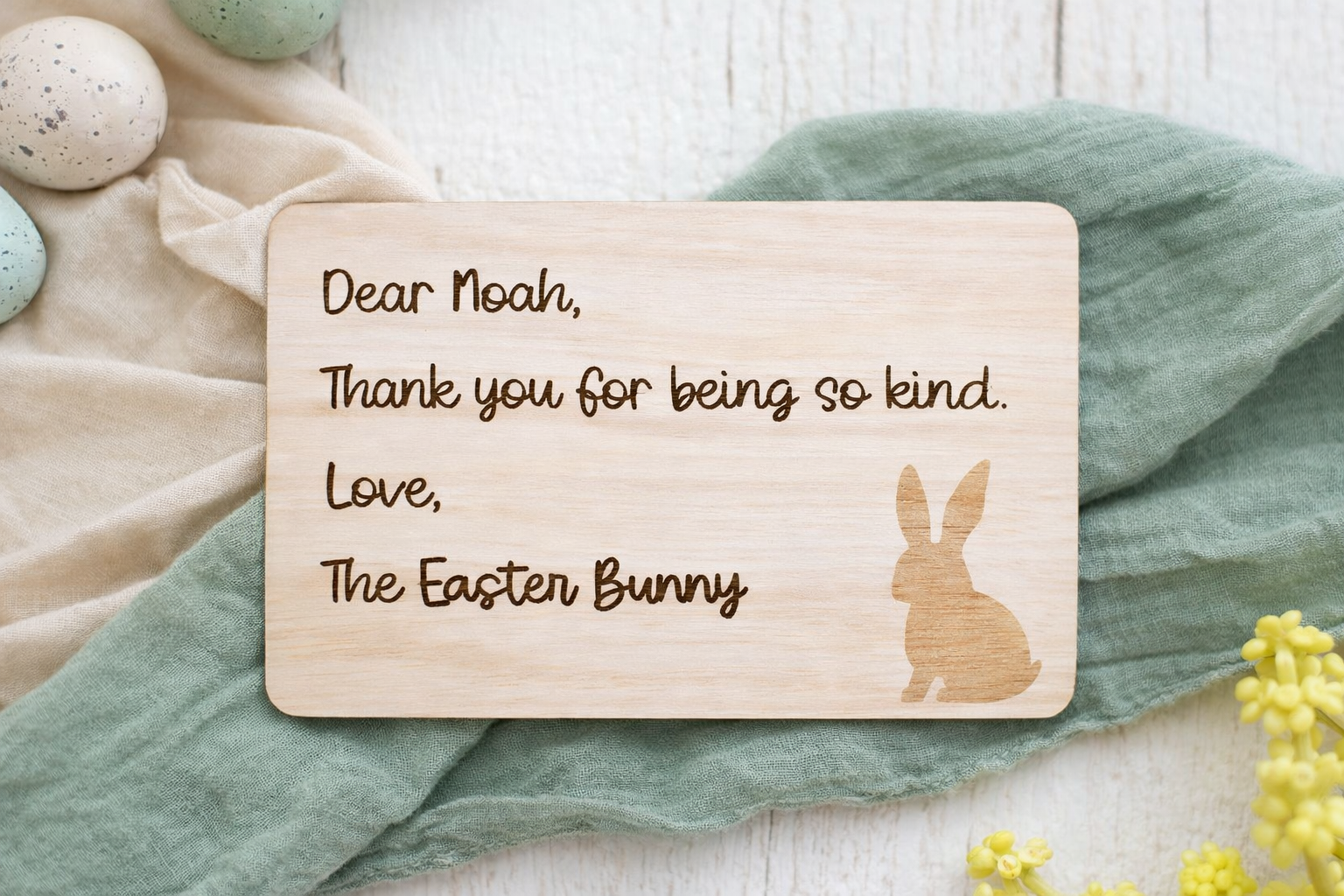 Wooden card with a message from 'The Easter Bunny' on a soft fabric background.