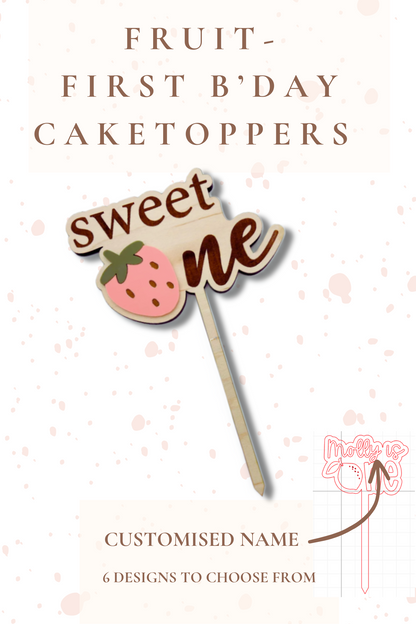 Cake topper with 'sweet one' text and strawberry design on a white background with pink polka dots.