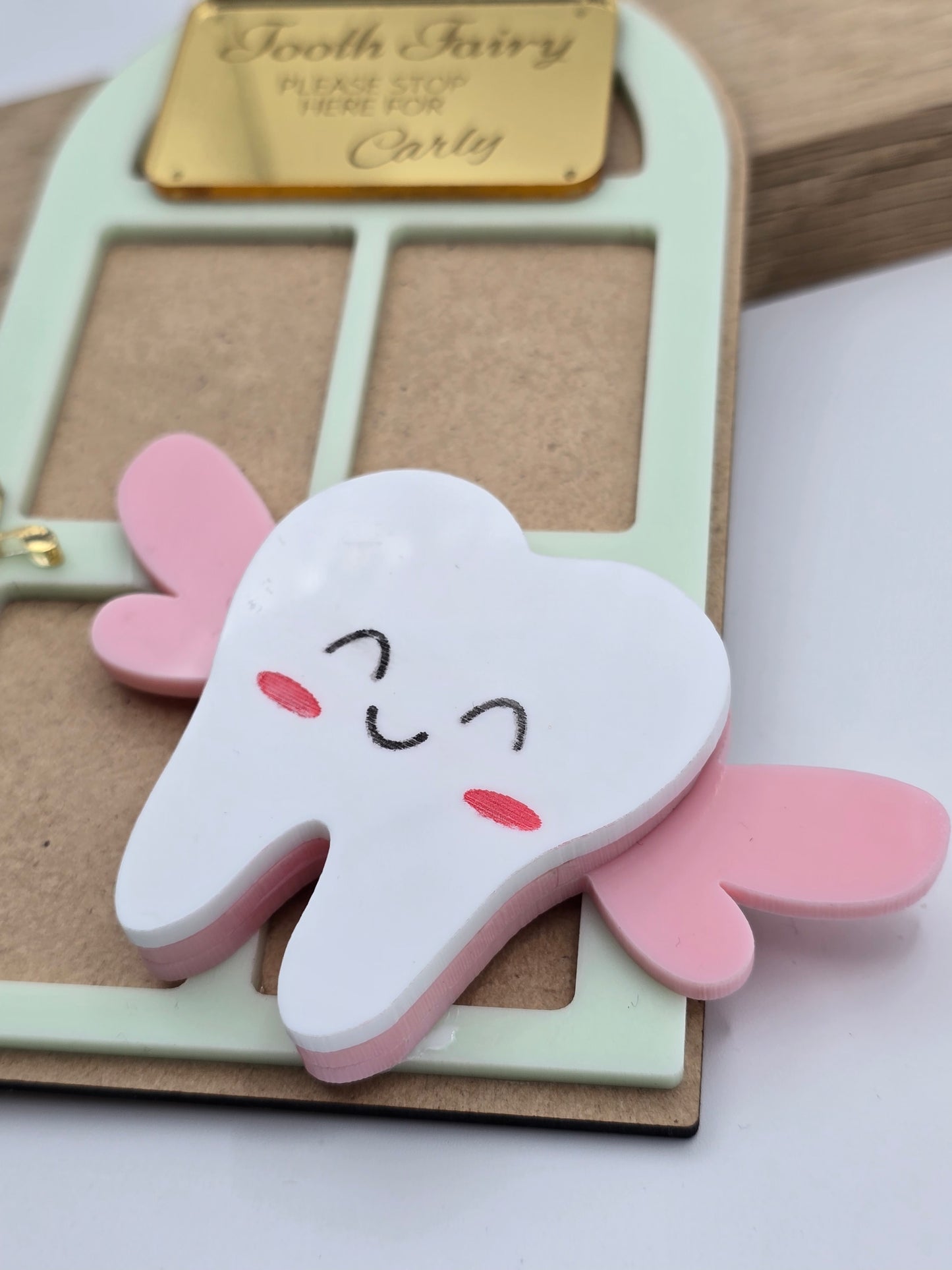 PeppaTree Designs custom tooth fairy door name sign keychain hanging on a door, featuring whimsical design and personalized text.