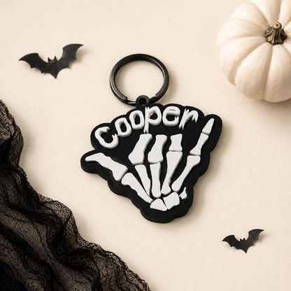 Halloween Shaka Skeleton Hand Bag Tag keychain by PeppaTree Designs featuring a spooky skeleton hand with a shaka gesture.