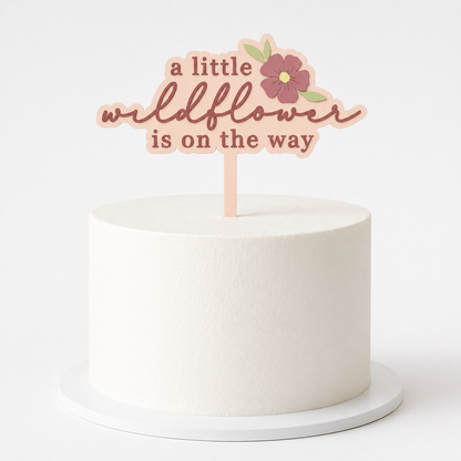 White cake topped with a wildflower-themed cake topper from PeppaTree Designs, perfect for celebrating special occasions.