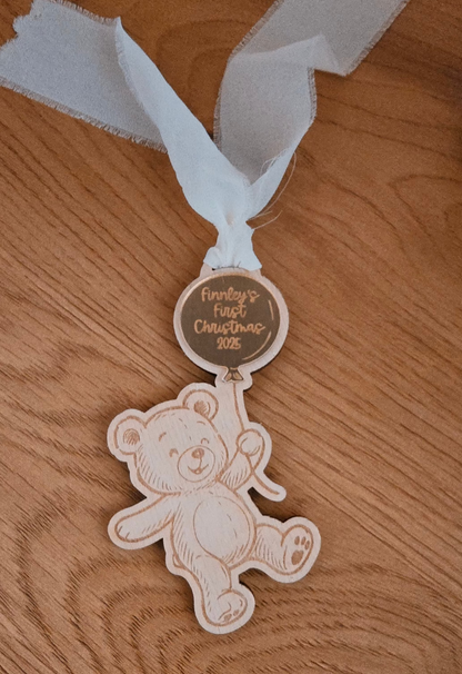 Wooden teddy bear ornament with a ribbon on a wooden surface